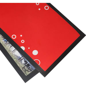 A red bar runner counter mat with a black edge featuring circular designs and a textured surface.