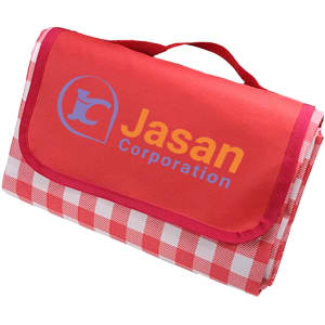 A large picnic blanket in red with a checked pattern and a logo on one side, neatly folded with a handle.
