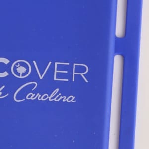 A purple phone holder with a silicone lanyard and a logo design.