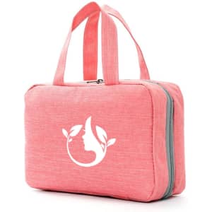 A pink, large capacity hanging toiletry bag with dual handles and a logo featuring a silhouette and leaves.