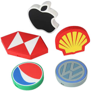 A collection of custom shaped PVC wireless chargers in various colours, featuring different logos and designs.