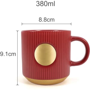 A ceramic coffee mug in red with a bronze medal detail, featuring a ribbed design and a handle.