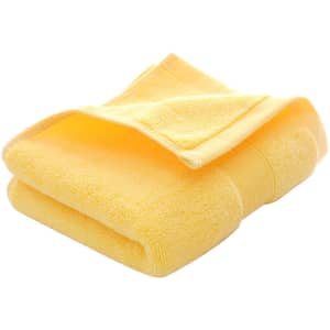 A folded embroidered cotton hand towel in a vibrant yellow colour, featuring a textured surface and a logo.
