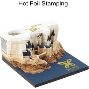 A 3D paper carving notepad in shades of beige and white, featuring intricate castle designs and a logo on the base.