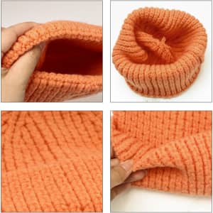 A twisted cable cuffed beanie in a warm orange colour, showcasing its textured design and interior lining.