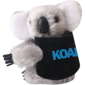 A grey koala plush toy with a black pouch featuring a logo, designed to clip on items.