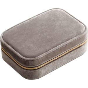 A grey velvet jewellery box with a compartment and a zip closure. It features a subtle texture and a gold zipper.