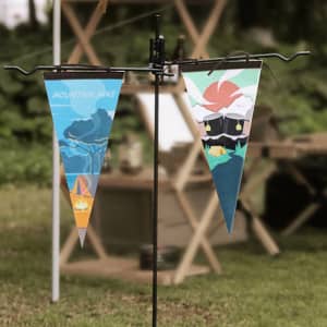 Two felt pennants in blue and green featuring outdoor designs, hanging from a black display stand.