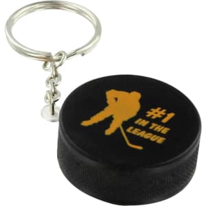 A black hockey puck stress reliever attached to a metal keyring, featuring a silhouette and gold text.