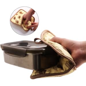 A large quilted pot holder in cream with brown designs, being used to hold a metal container.