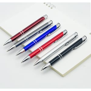 A collection of six metal click pens in red, blue, silver, black, and maroon, displayed with an open notepad.