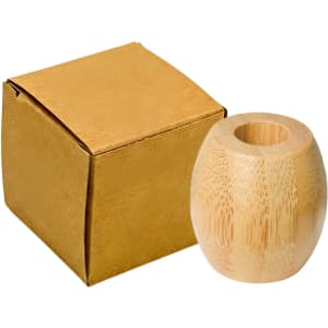 A bamboo toothbrush stand in a natural tone next to a golden box. The stand has a smooth, rounded shape.