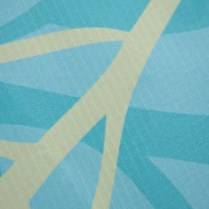 A rectangular outdoor blanket in shades of blue with a light leaf pattern. The fabric features a subtle texture.