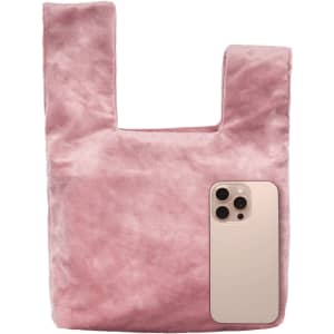 A pink velvet wrist bag with a smooth texture, featuring a phone next to it for size comparison.