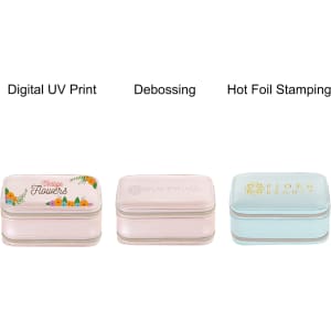 A collection of three jewellery cases in various pastel colours, featuring different decorative designs and finishes.