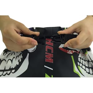 A dry bag featuring vibrant colours and a PVC window, being secured by hands with adjustable straps.
