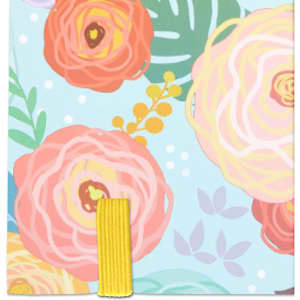 A notebook with a full-colour floral cardboard cover in pastel shades, featuring a yellow elastic band.