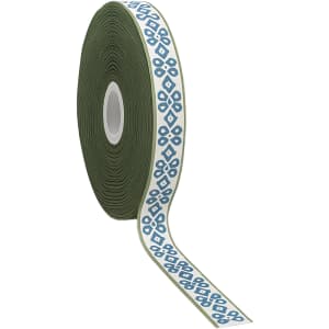 A roll of satin polyester ribbon featuring a geometric pattern in blue on a cream background, with a green core.