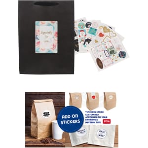 A large black paper bag with fabric flat handle, featuring a logo and accompanied by decorative stickers.