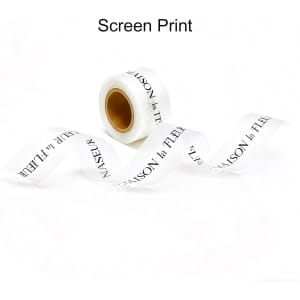A roll of white soft ribbon with black screen-printed text, featuring a logo at one end.