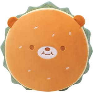 A round, plush toy shaped like a hamburger, featuring a smiling bear face and orange and green colours.