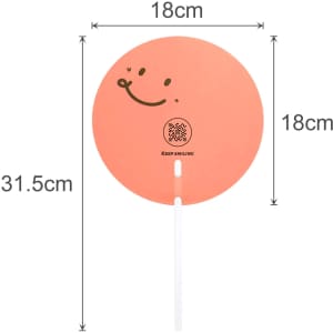 A custom-shaped transparent PVC hand fan in peach with a smiling face design and a white handle. Dimensions are 18cm by 31.5cm.