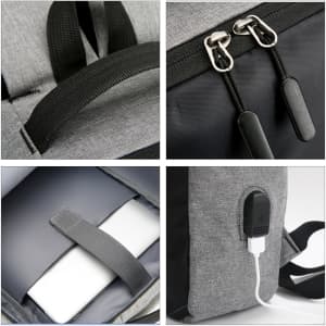 A grey laptop backpack with black accents features dual zippers, a USB charging port, and a padded compartment for a laptop.