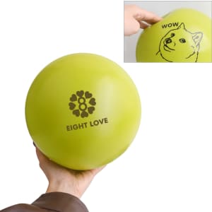A hand holds a bright green inflatable PVC ball featuring a logo and whimsical designs.