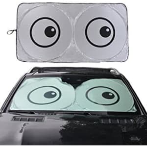 A foldable car shade featuring a playful design with two large eyes, showcased on a car windshield.