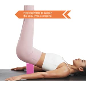 A pink EVA yoga block on a mat supporting a person performing an exercise. The individual wears light-coloured activewear.