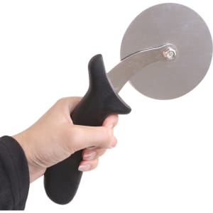 A pizza cutter with a stainless steel blade and a black ergonomic handle, held by a hand.