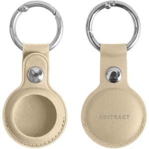 A beige PU leather AirTag holder with a keyring, featuring a circular design and a small metal snap button.