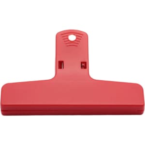 A red plastic magnetic clip with a flat base and a hole for hanging, featuring a simple design.