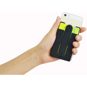 A black phone wallet stand is held in a hand, attached to the back of a smartphone, with cards inserted.