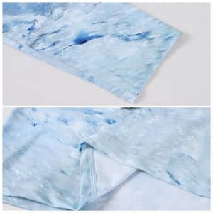 A close-up of a light blue polyester spandex polo shirt, featuring a sublimated wave pattern. The garment has a seamless finish.