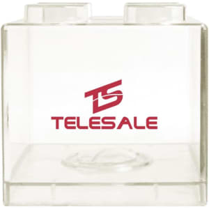 A clear square block coin bank with two stud-like tops and a logo on the front.