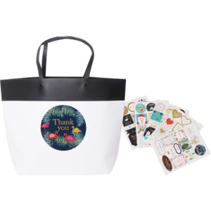 A medium black and white boutique paper bag with black handles, accompanied by various decorative stickers.