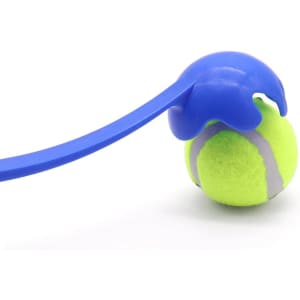 A blue ball thrower holds a green tennis ball, featuring a textured grip and curved handle for easy use.