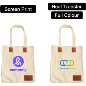 A beige canvas bag with leather handles, featuring a logo on each side and a magnetic snap closure.