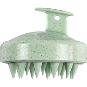 A green hair scalp massager with a textured surface and pointed bristles, featuring a hanging loop for easy storage.