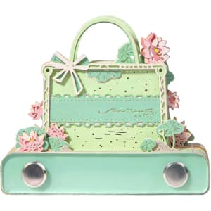 A green 3D paper art handbag tear-off notepad featuring pink floral accents and a decorative handle.