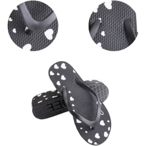 A pair of black thongs with white heart patterns, showing a close-up of the strap and sole texture.