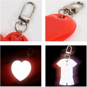 A reflective keychain in the shape of a red heart and a white shirt, featuring a metal clip for attachment.