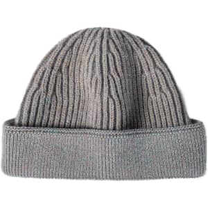 A round beanie in grey with a ribbed texture and folded cuff. It features a logo on the side.