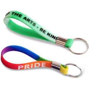 Two silicone key rings in vibrant colours, one featuring a green and white design and the other in a rainbow gradient.