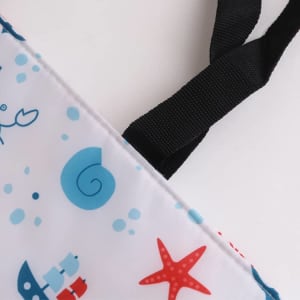 A large cooler tote bag in white featuring blue and red marine-themed designs, with black straps.