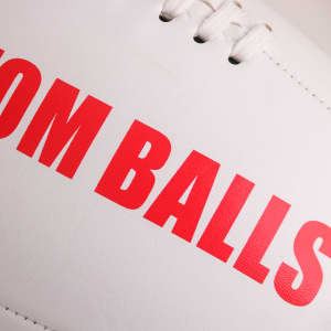A white AFL ball with red text, featuring stitching and a logo. Perfect for leisure and outdoor sports.