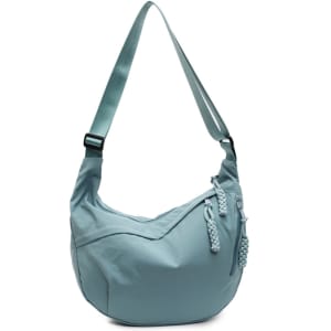 A light blue Dumpling Crossbody Bag featuring a curved shape and adjustable strap with decorative pulls.