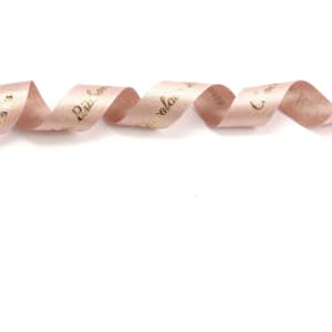 A satin ribbon in glitter gold and soft pink tones, featuring a wavy design and a logo.