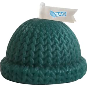 A green candle shaped like a knitted beanie, featuring a small flag with a logo.